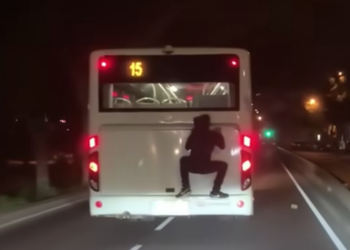 Passeggero immortalato mentre viaggia “appeso” sul retro di un autobus della Tallinja